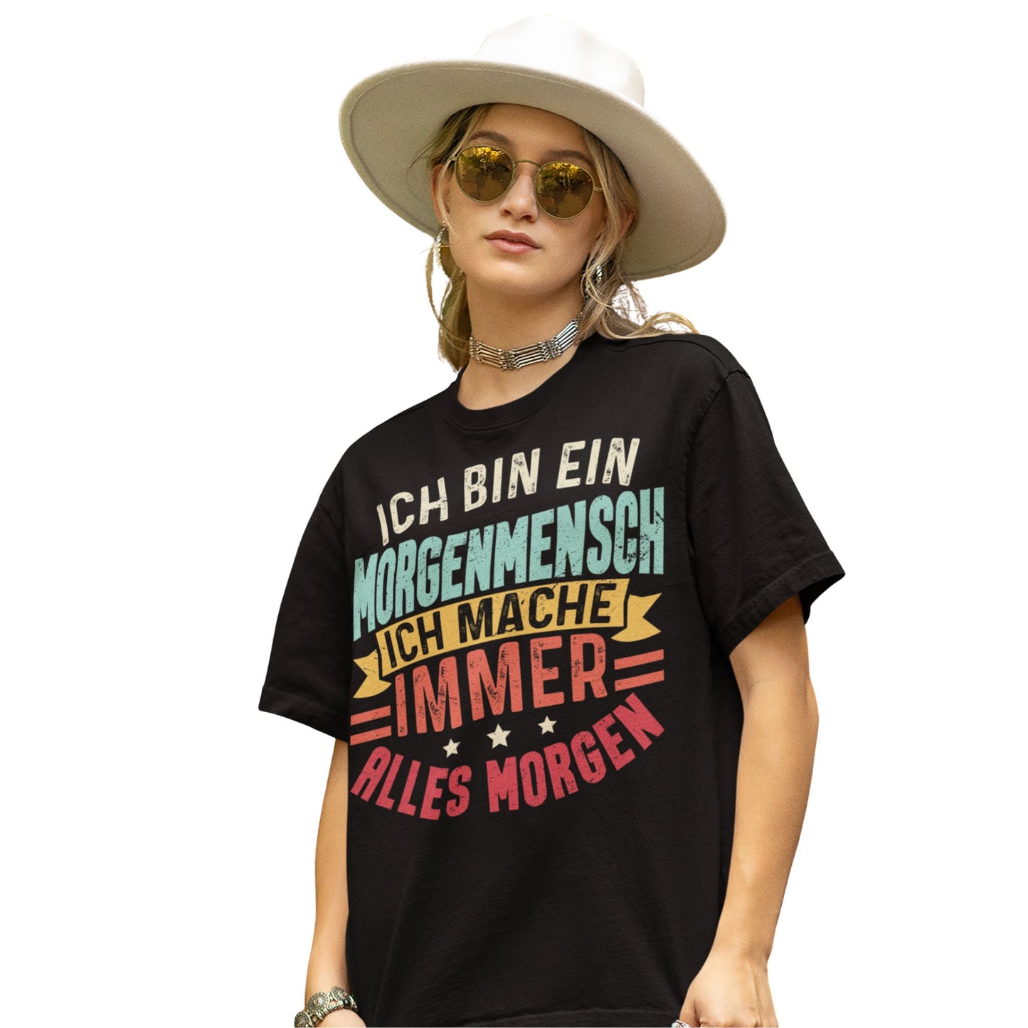 Frau trägt Schwarzes T-Shirt mit Spruch „Ich bin ein Morgenmensch – Ich mache immer alles morgen“ in bunten Retro-Farben