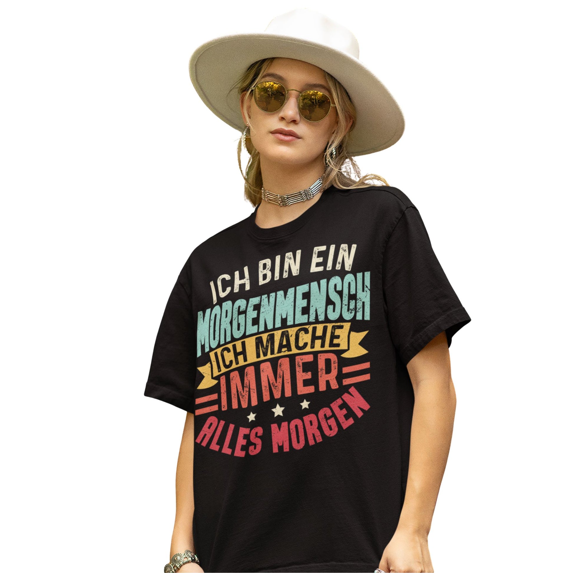 Frau trägt Schwarzes T-Shirt mit Spruch „Ich bin ein Morgenmensch – Ich mache immer alles morgen“ in bunten Retro-Farben