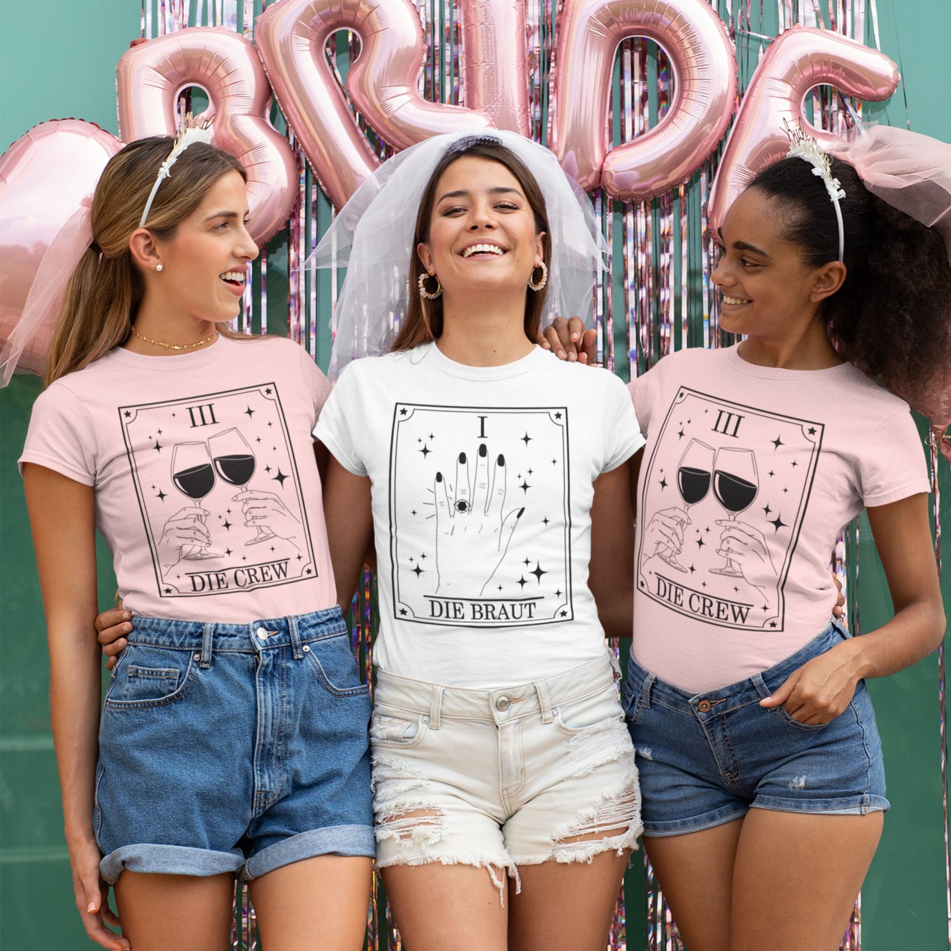 JGA Shirt Set mit Tarotkarten-Design – weißes Shirt „Die Braut“ mit Ringmotiv (Karte I) & rosa Shirts „Die Crew“ mit Weingläsern (Karte III) für den Junggesellinnenabschied