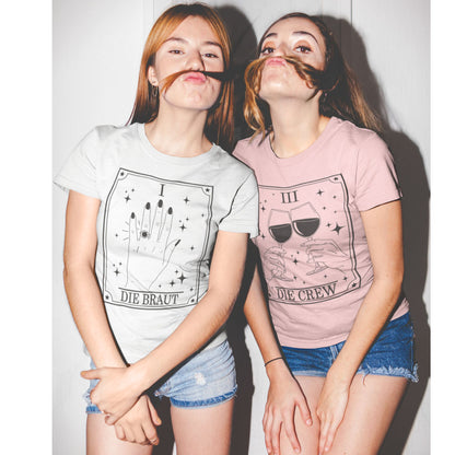 JGA Shirt Set mit Tarotkarten-Design – weißes Shirt „Die Braut“ mit Ringmotiv (Karte I) & rosa Shirts „Die Crew“ mit Weingläsern (Karte III) für den Junggesellinnenabschied