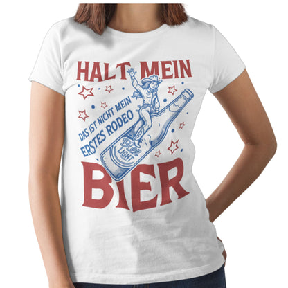 Weißes Damen T-Shirt im Unisex-Schnitt mit Aufdruck „Halt mein Bier – Das ist nicht mein erstes Rodeo“ und Illustration einer Rodeo-Reiterin auf einer Bierflasche – lustiges Partyshirt für Bierliebhaber
