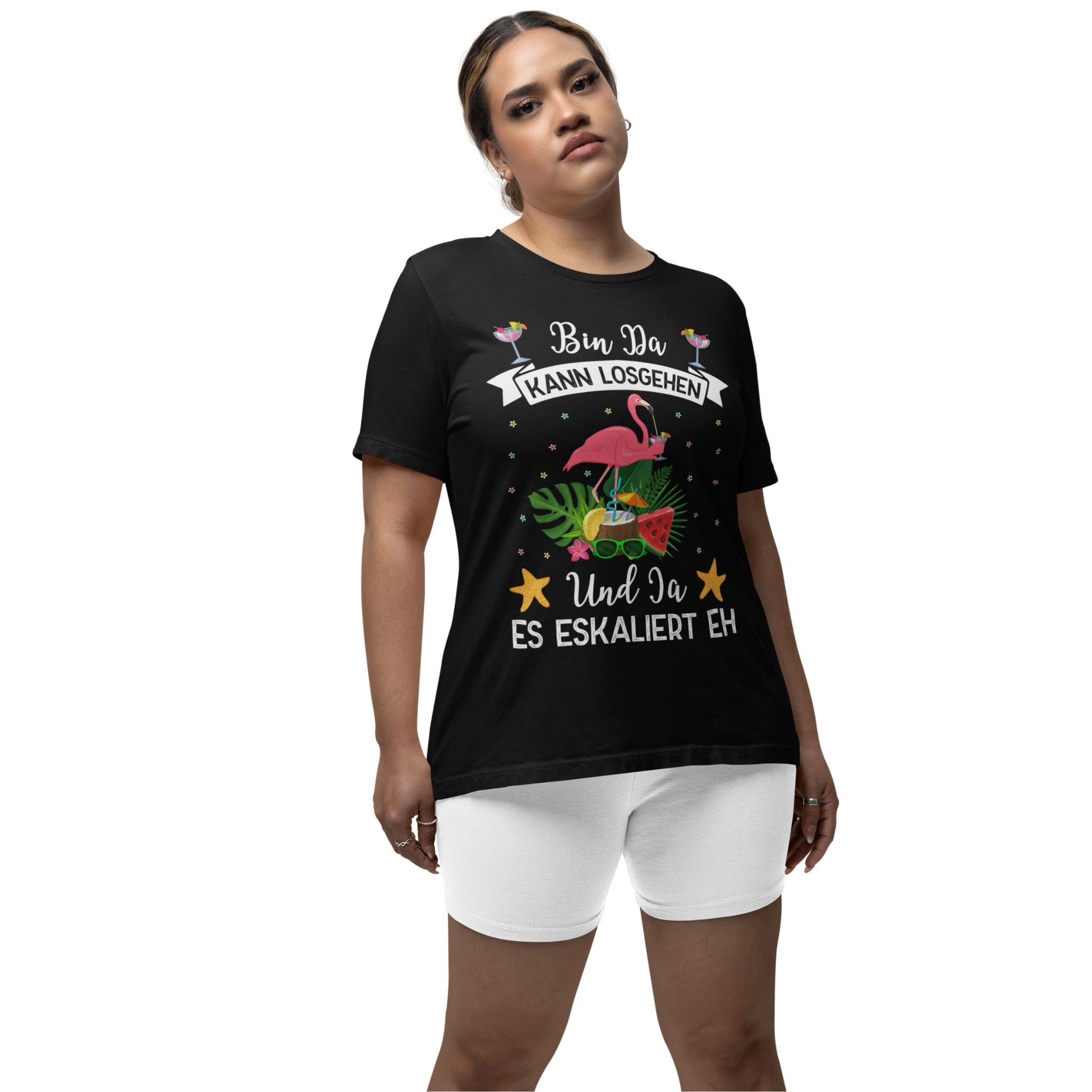 Eine junge Erwachsene trägt farbige Partyshirts mit Flamingo-Motiv und dem Spruch „Bin da, kann losgehen – Und ja, es eskaliert eh“