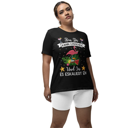 Eine junge Erwachsene trägt farbige Partyshirts mit Flamingo-Motiv und dem Spruch „Bin da, kann losgehen – Und ja, es eskaliert eh“