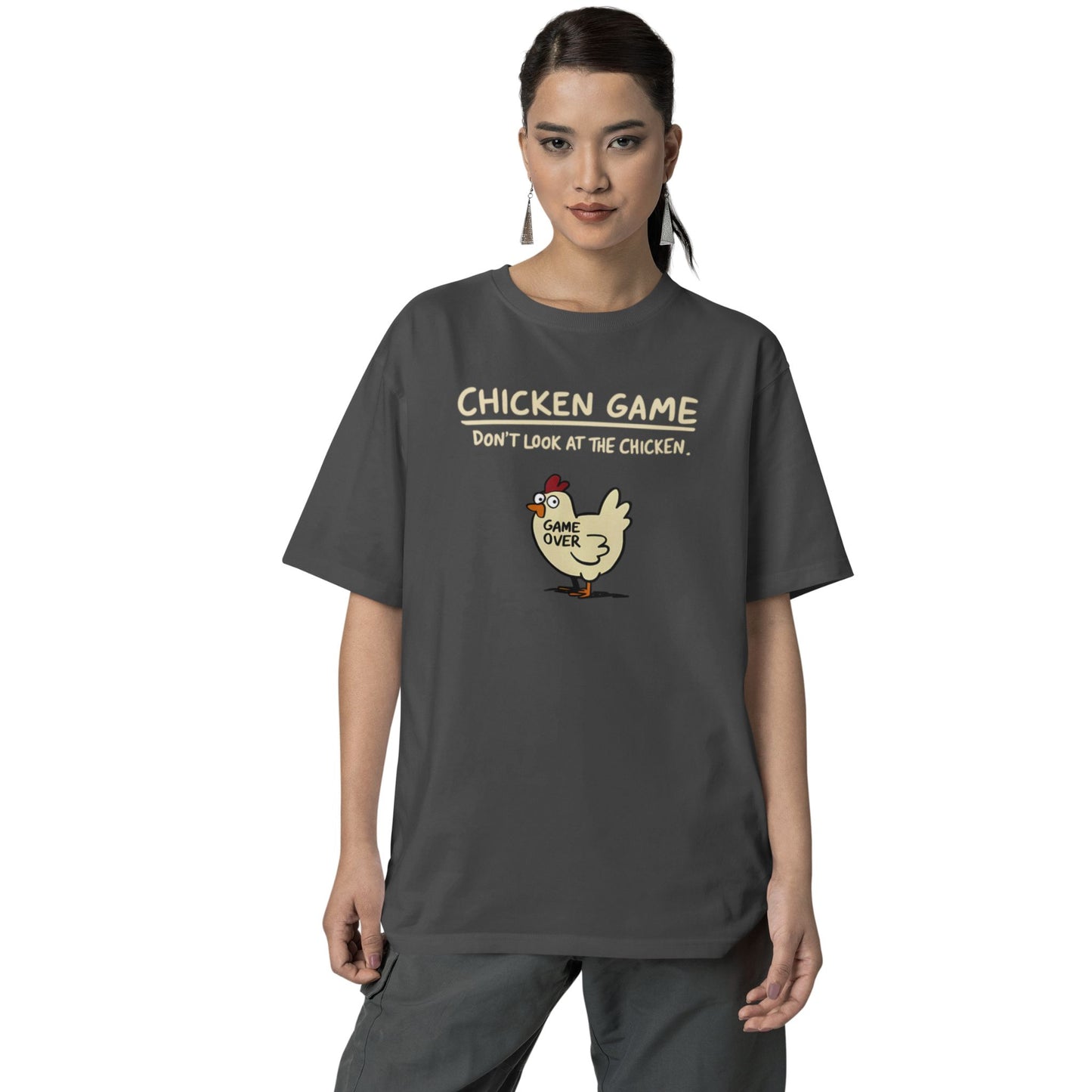 Frau trägt Unisex T-Shirt in Dunkelgrau mit Cartoon-Huhn und Spruch „Chicken Game – Don’t look at the chicken. Game Over“ – lustiges Shirt für Nerds & Partys