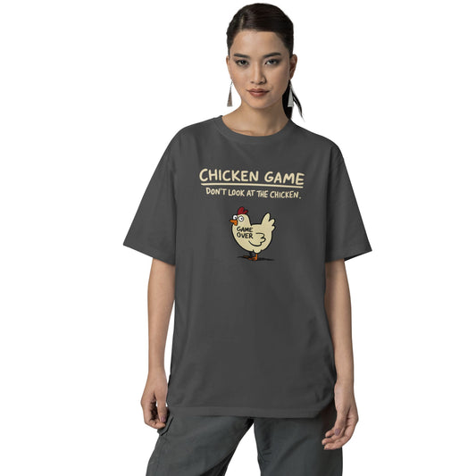 Frau trägt Unisex T-Shirt in Dunkelgrau mit Cartoon-Huhn und Spruch „Chicken Game – Don’t look at the chicken. Game Over“ – lustiges Shirt für Nerds & Partys