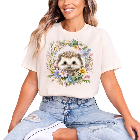 Frau trägt Beiges T-Shirt mit süßem Igel-Motiv im bunten Blumenkranz – Unisex Tiermotiv Shirt