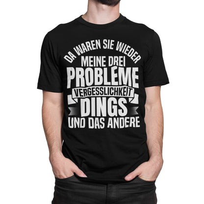 Mann trägt Schwarzes T-Shirt mit weißem Spruch „Da waren sie wieder, meine drei Probleme: Vergesslichkeit, Dings und das andere“ – Lustiges Funshirt Unisex