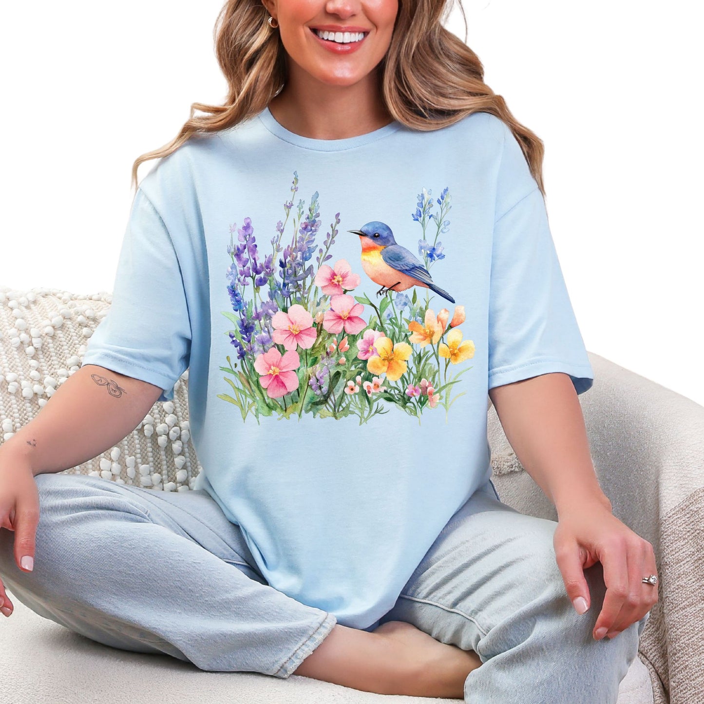 Frau trägt hellblaues  T-Shirt mit buntem Vogel und Blumenmotiv – Natur & Frühling Design Unisex