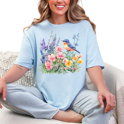 Frau trägt hellblaues  T-Shirt mit buntem Vogel und Blumenmotiv – Natur & Frühling Design Unisex